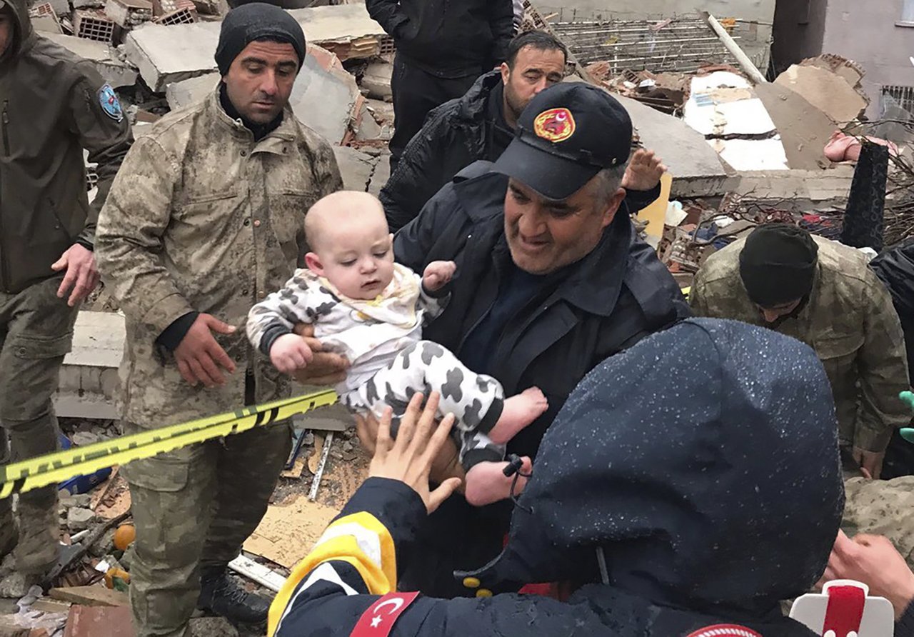 Gyermeket mentenek ki egy összeomlott épületből a törökországi Malatya városban a földrengés után. 2023. február 6. Fotó: MTI/AP/Depo Photos