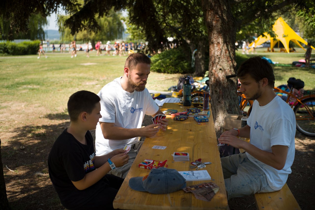 Testvérek a parton kártyáznak egy gyerekkel Erzsébet Tábor Zánka 2022 - Fotó: Todoroff Lázár